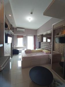 una grande stanza con un letto e una tv di Bima Hotel a Surabaya