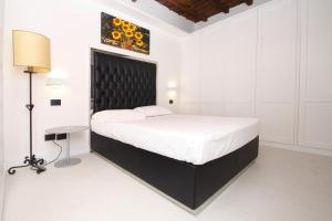 ローマにあるLHP Suite Roma Trastevereの白いベッドルーム(大型ベッド1台、テーブル付)