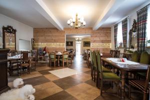 restauracja ze stołami, krzesłami i żyrandolem w obiekcie Gronik w mieście Groń
