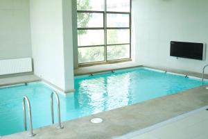 a swimming pool in a room with a large window at Loica Suites in Santiago