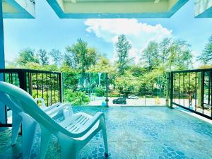 a patio with two chairs and a swimming pool at Emma in Ban Pak Khlong Phe