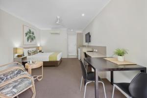 a hotel room with a bed and a table and chairs at Beachside Boutique Motel Mackay in Mackay +50 photos