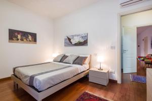 een slaapkamer met een bed en een tafel met een lamp bij Cattaneo Arena Apartaments in Verona