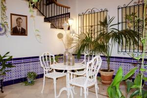 a table and chairs in a room with plants at Hotel Mairena in Mairena del Alcor