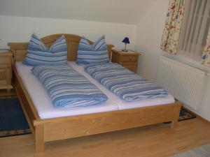 ein Bett mit blauen und weißen Kissen darauf in der Unterkunft Ferienhaus Ehrenreith in Göstling an der Ybbs