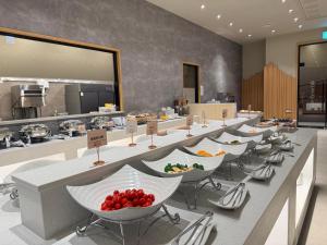 a row of tables with bowls of fruit on them at Gwangju The IN Hotel in Gwangju