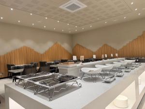 a waiting room with a row of tables and chairs at Gwangju The IN Hotel in Gwangju