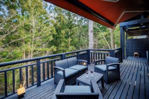 a deck with chairs and tables and trees at Villa Qualite ヴィラカリテ in Zao