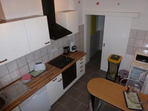eine Küche mit weißen Schränken und einem Waschbecken und einem Tisch in der Unterkunft Ferienwohnung Pretz in Braubach