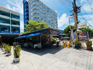 a restaurant with a blue awning in front of a building at Emma in Ban Pak Khlong Phe