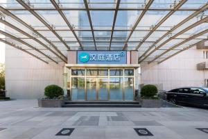 a building with a car parked in front of it at Hanting Hotel Beijing Xizhimen in Beijing