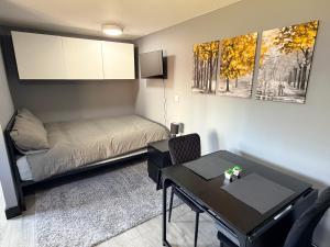 a small room with a bed and a table at Leatherhead Studios by WorkStay in Leatherhead