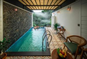 two people in a swimming pool in a house at The Feel Munnar Resort in Munnar