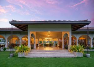 a building with a porch with two potted plants at Luxury Golf and Relaxation in Gonapola