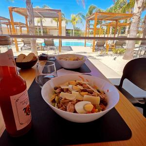 a table with a bowl of food and a bottle of sauce at CIRERA SICILY in Marzamemi