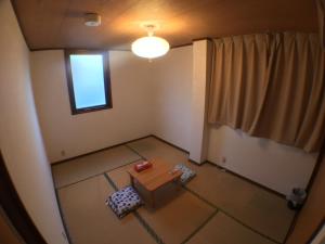 einen Blick über ein Zimmer mit einem Tisch und einem Fenster in der Unterkunft Arashiyama Bamboo Guest House in Kyoto