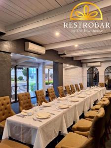 a long table with white tables and chairs in a room at The Town House Motor Inn in Goondiwindi