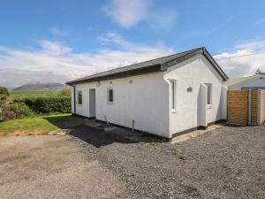 a white building with a driveway in front of it at Maes Y Coed in Pwllheli