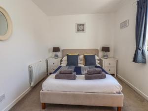a bedroom with a bed with two pillows on it at Maes Y Coed in Pwllheli