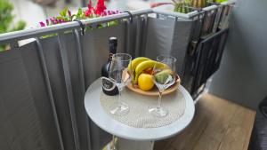 a table with a bowl of fruit and two wine glasses at Loft@Lounge in Grado-Pineta