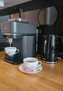a coffee maker and two cups of coffee on a counter at Apartament Sun Hill in Wisła
