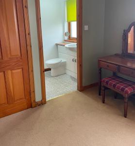 a bathroom with a toilet and a sink and a wooden door at Brackenbrae Holiday Cottage in Acharacle +46 photos
