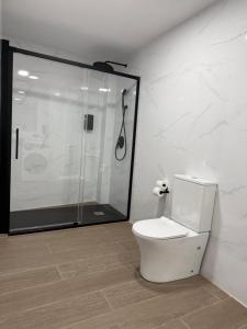 a white bathroom with a shower and a toilet at Apartamentos Nuevos en Valencia in Valencia