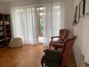 a living room with two chairs and a table at Tūlevél/Pine-needles in Tata