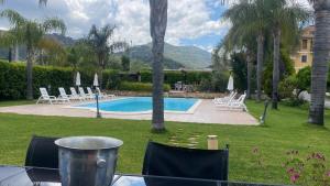 a view of a pool with chairs and a table at Sole nascente in Furci Siculo