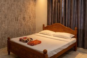 a bed with two pillows on top of it at Kattil Madurai in Madurai
