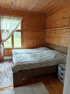 a bedroom with a bed in a wooden cabin at Ranta mökki in Kouvola