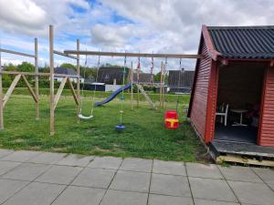 a playground with a swing set in a yard at Villa EVchargeFree in Horsens