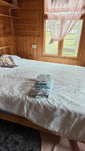 a bed in a wooden room with a window at Ranta mökki in Kouvola