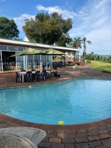 a swimming pool in front of a house at Mon Desir Estate - NR3 in Pietermaritzburg