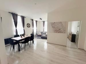 a dining room and living room with a table and chairs at Apartmány 68 in Kámen