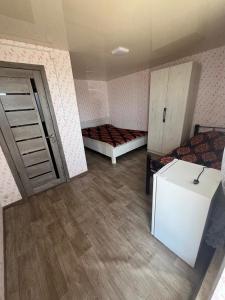 a room with two beds and a white refrigerator at Prestizh Guest House in Tamchy