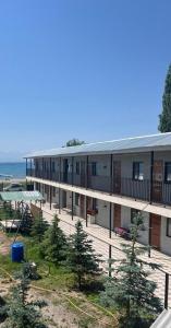 a building on the beach next to the ocean at Prestizh Guest House in Tamchy