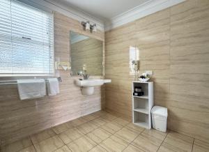a bathroom with a sink and a mirror at Gunnedah Lodge Motel in Gunnedah +56 photos