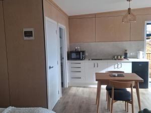 a small kitchen with a table and a microwave at Totaranui Accommodation Chalet 2 in Tata Islands