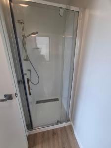 a shower with a glass door in a bathroom at Totaranui Accommodation Chalet 2 in Tata Islands