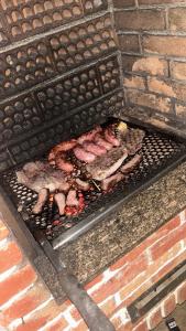 a grill with meat and other food on it at Pousada Peruibe Praia Centro in Peruíbe