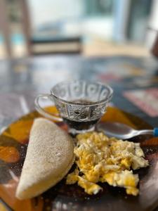 a plate of food with a cup of tea at Pousada Peruibe Praia Centro in Peruíbe