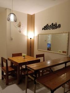 a dining room with two wooden tables and a mirror at Homestay D' Aura Pool Melaka in Ayer Keroh