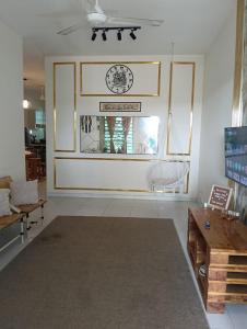a living room with a clock on the wall at Homestay D' Aura Pool Melaka in Ayer Keroh