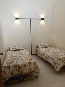 two beds sitting next to each other in a room at Homestay D' Aura Pool Melaka in Ayer Keroh