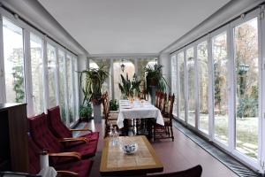 a conservatory with a table and chairs and windows at Rapsodia Pension in Suceava