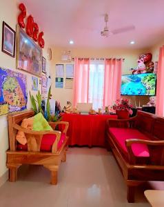 a living room with a table and a couch and a table with a laptop at Jenalfe Guest House in Camiguin