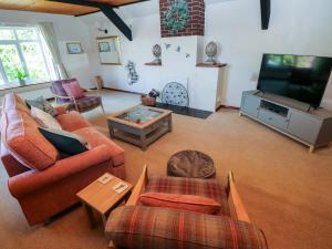 a living room with couches and a flat screen tv at The Stables in Flemingston