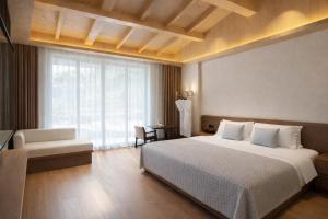 a bedroom with a large bed and a large window at Tuke Light Hotel Jiuzhaigou 途客轻居酒店九寨沟店 in Jiuzhaigou +22 photos