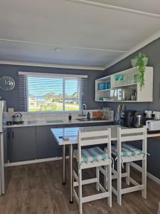 a kitchen with a table and chairs and a counter at 7onthebeach unit 3 in Jeffreys Bay